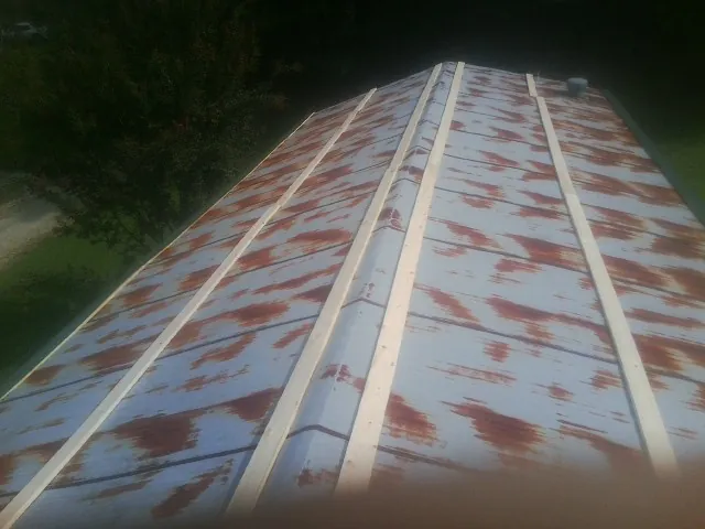 Rusted metal roof panels with new wood purlins before replacement — Storm Damage Roof Repair in Moab by Roofing Brothers
