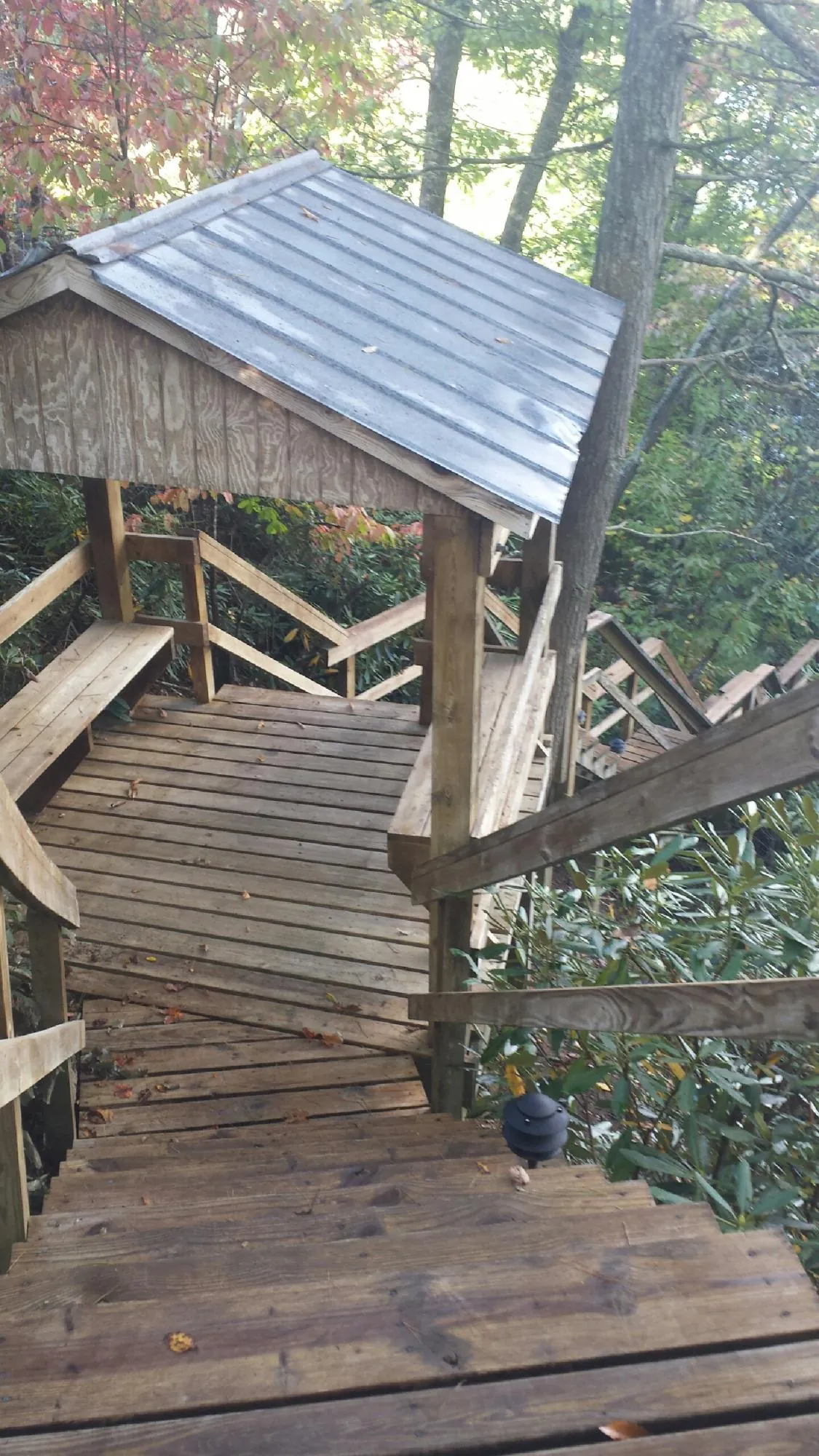Metal roofed shelter over wooden steps on a wooded walkway — Skylight Repair & Installation work by our crew in Moab