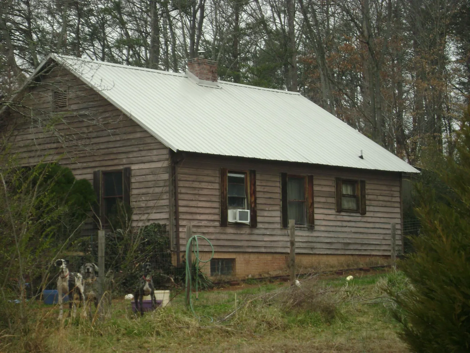 White metal roof on an old wood sided farmhouse, from a Metal Roof Installation job in Moab